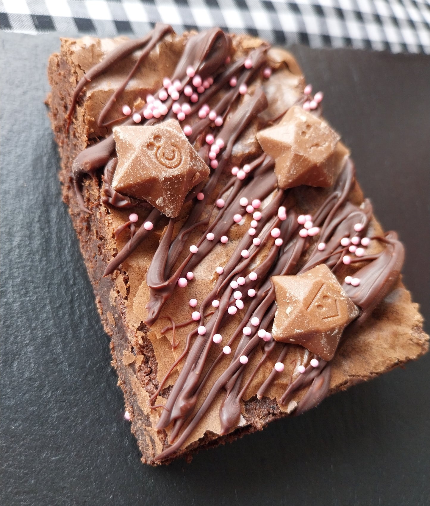 Close up image of a chocolate brownie topped with Magic Stars and pink sprinkles