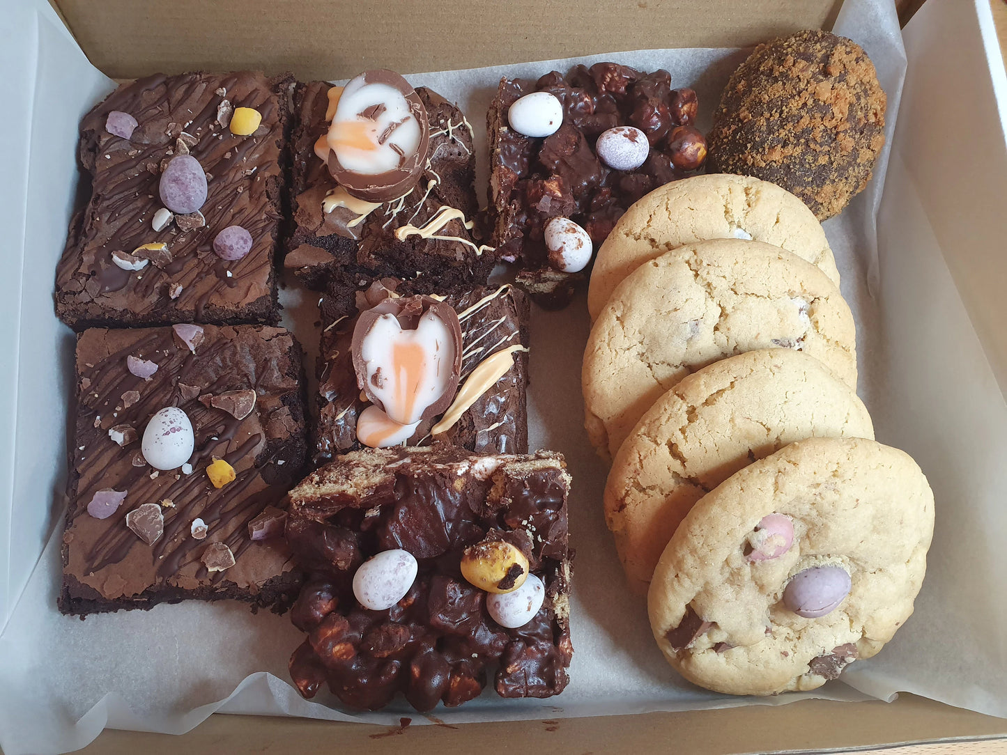 A treat box containing 2 mini egg brownies, creme egg brownies, 4 mini egg cookies, 2 easter rocky road and one brownie scotch egg