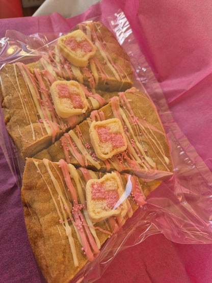 4 slices of battenberg cookie pie slices wrapped in clear cellophane on pink tissue paper