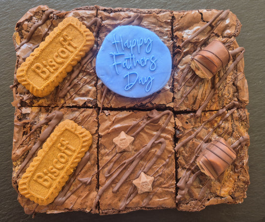 Six chocolate brownies topped with Biscoff biscuits and kinder bueno chocolate bar pieces. Includes a blue fondant topper which says Happy Father's Day