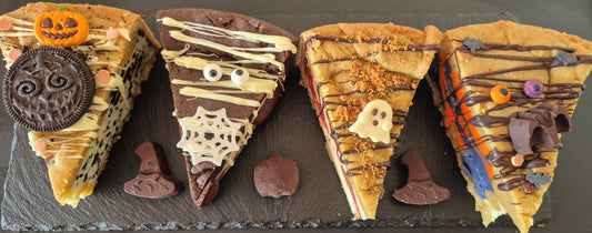 Four Halloween-themed cookie pie slices on a dark surface
