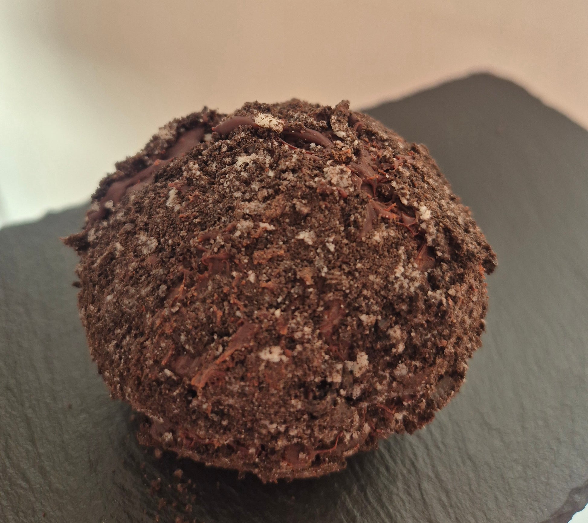 Chocolate Oreo brownie scotch egg with cookie crumb topping on a dark slate surface